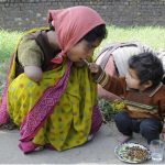 A handicapped mother being offered food from her child.