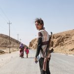 Yezidi girl carries an assault rifle to protect her family from ISIL.